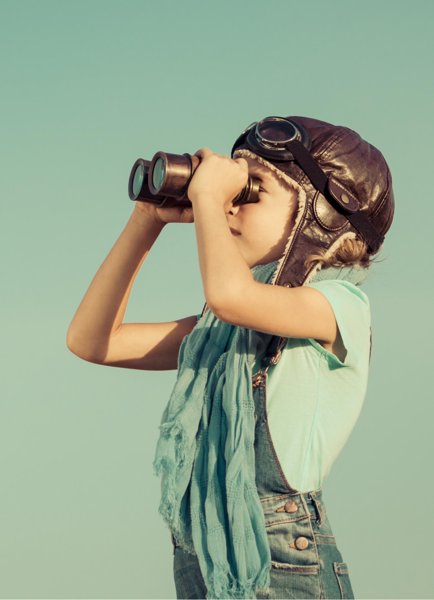 Person wearing a vintage helmet and scarf, looking through binoculars against a light green background